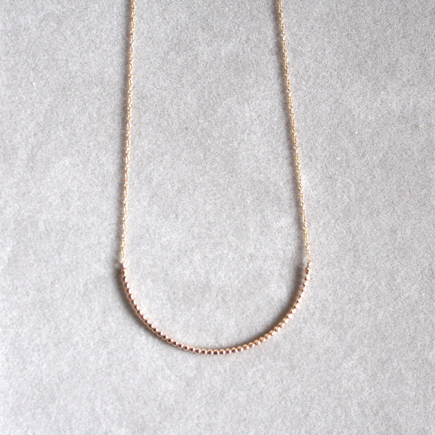 gold beaded arc necklace