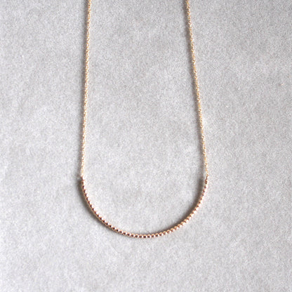 gold beaded arc necklace