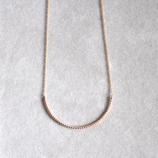 gold beaded arc necklace